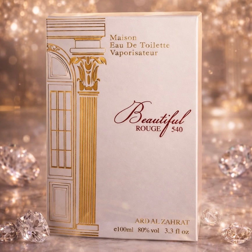 Perfume bottle packaging with gold and white design on a glittery background