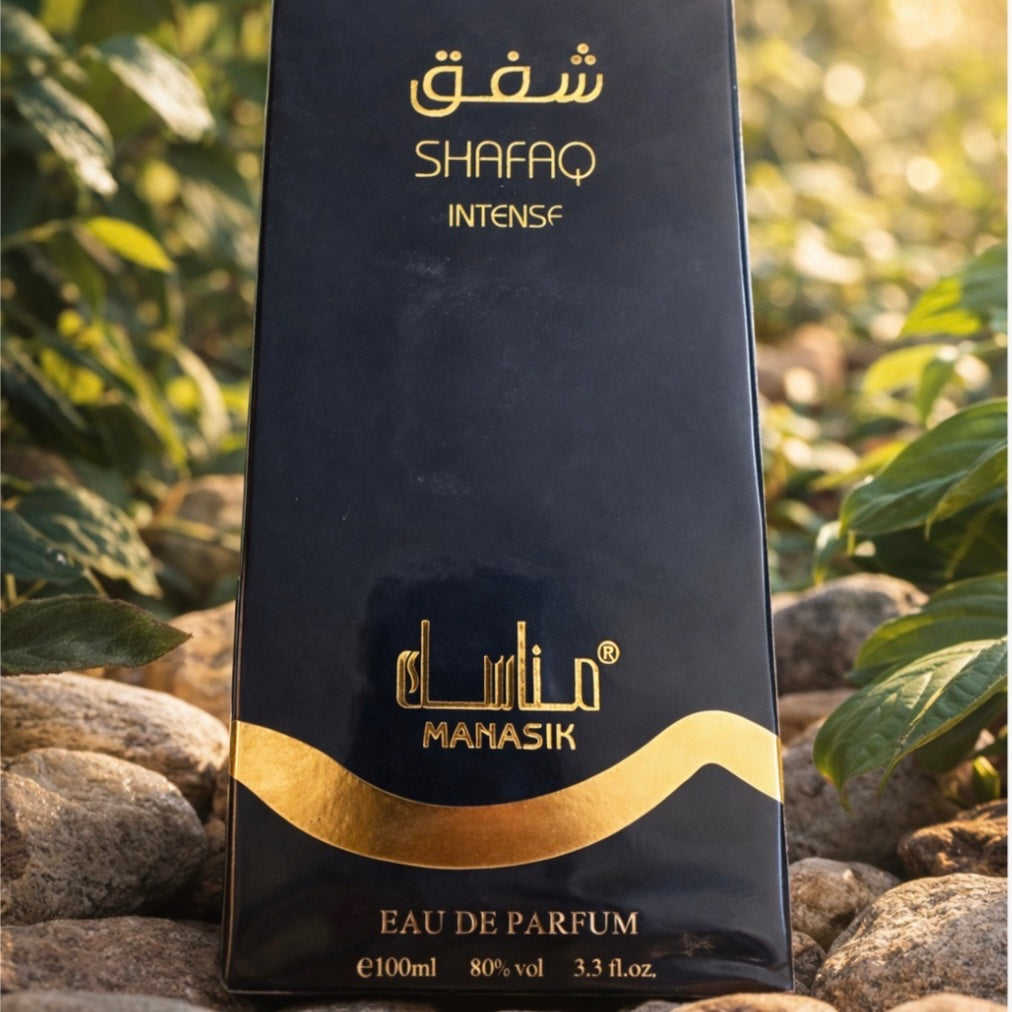 Manasik Shafaq Intense perfume bottle with gold text against a natural background